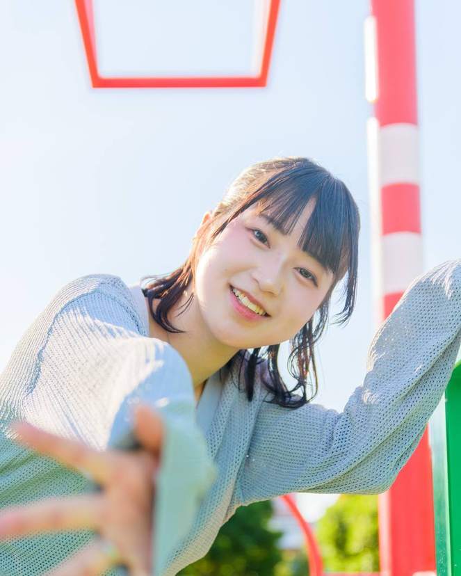 公園の遊具で笑う女性