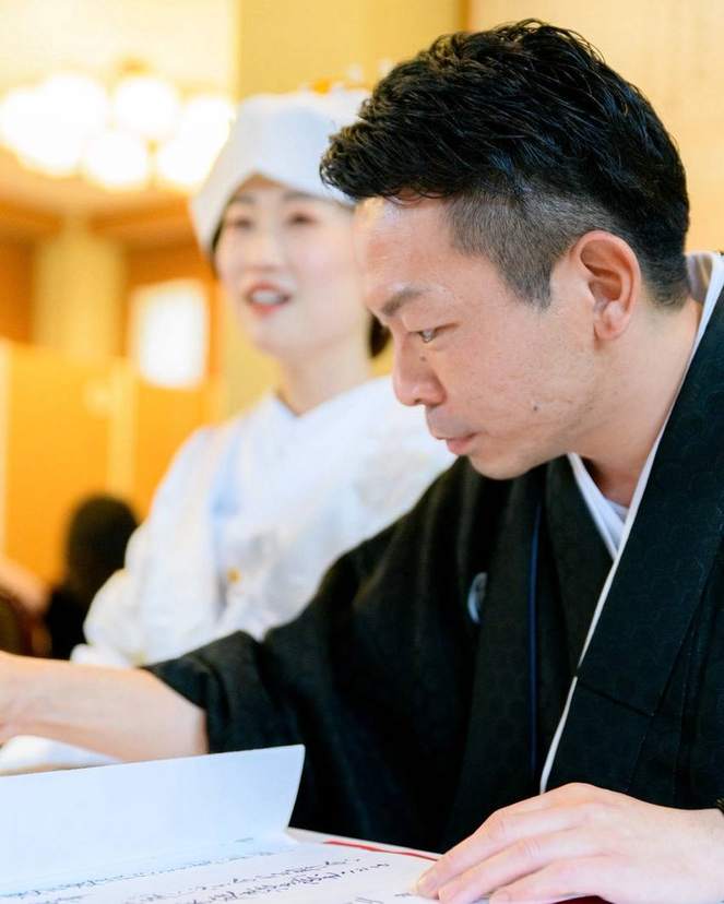 神前式で誓詞を読む新郎と新婦
