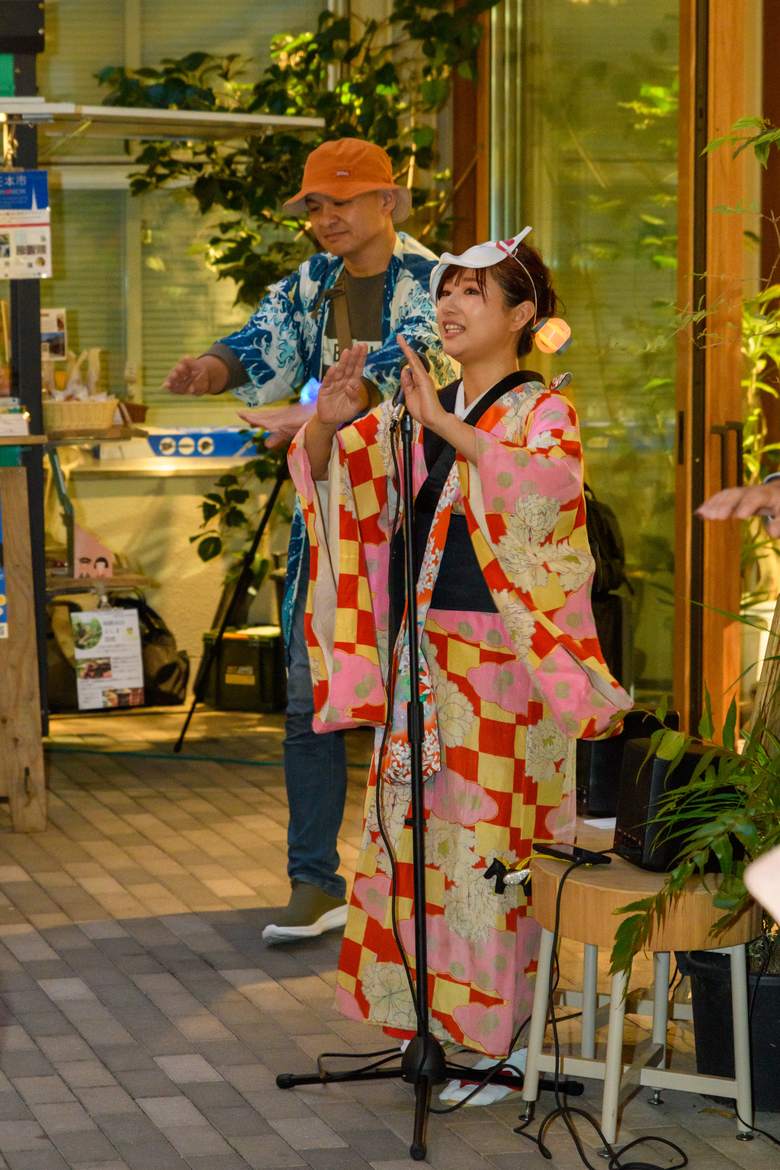 着物姿でマイクの前に立つ女性